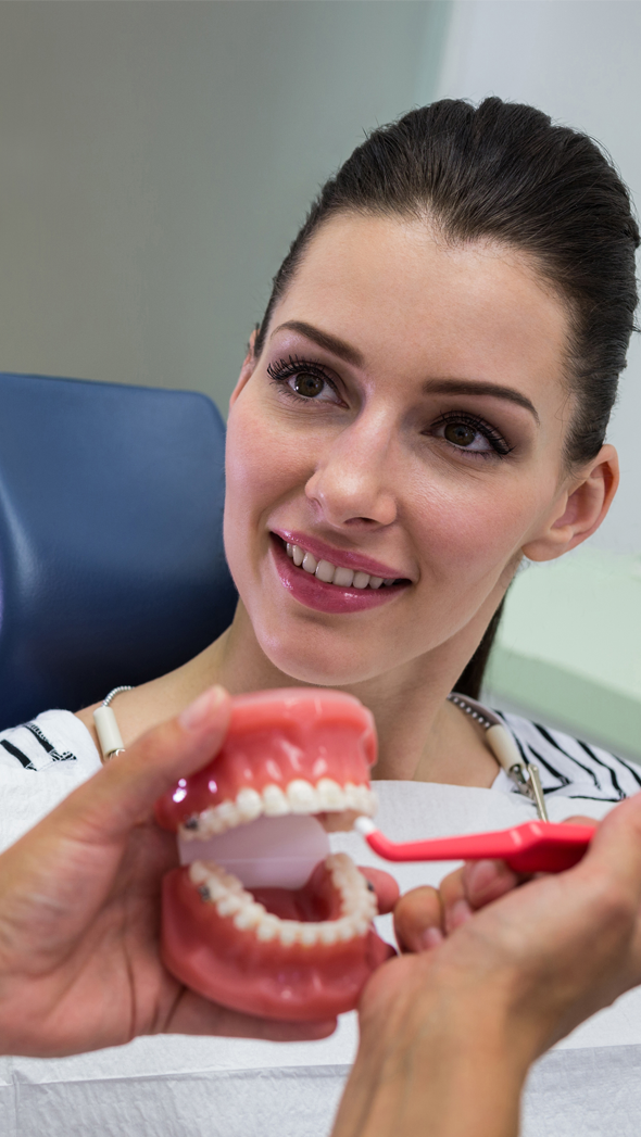 Profissional a apresentar uma prótese dentária